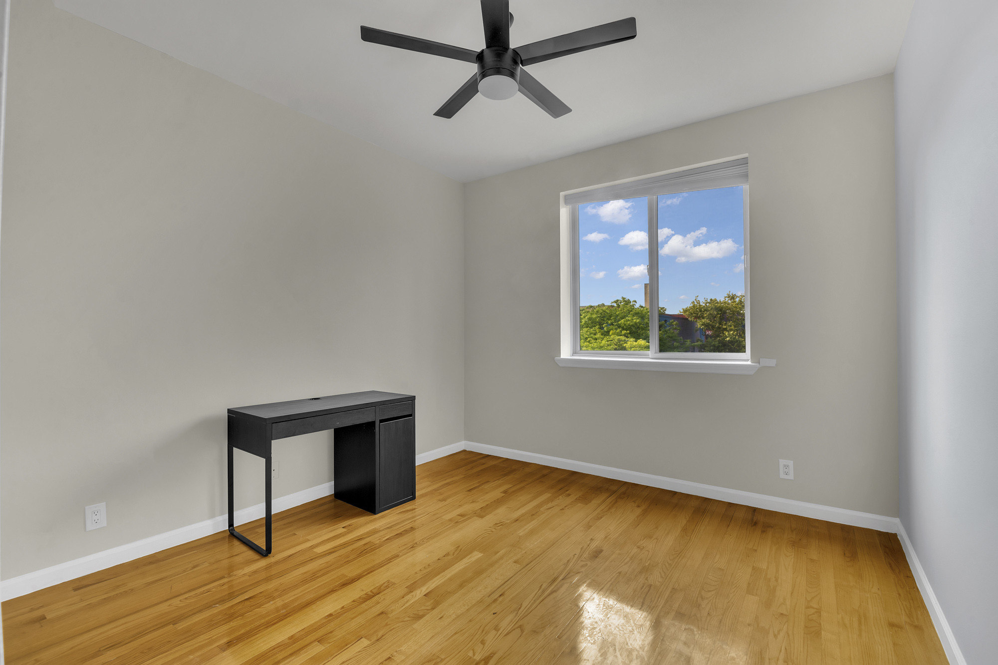 963 Kent Avenue, Unit D3 Brooklyn, NY 11205 - Photo 14 of 16 a view of an empty room with a window and wooden floor