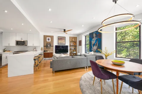 a living room with furniture a flat screen tv and a large window