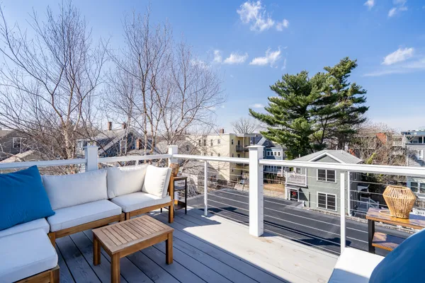 a view of a roof deck with couches and wooden floor