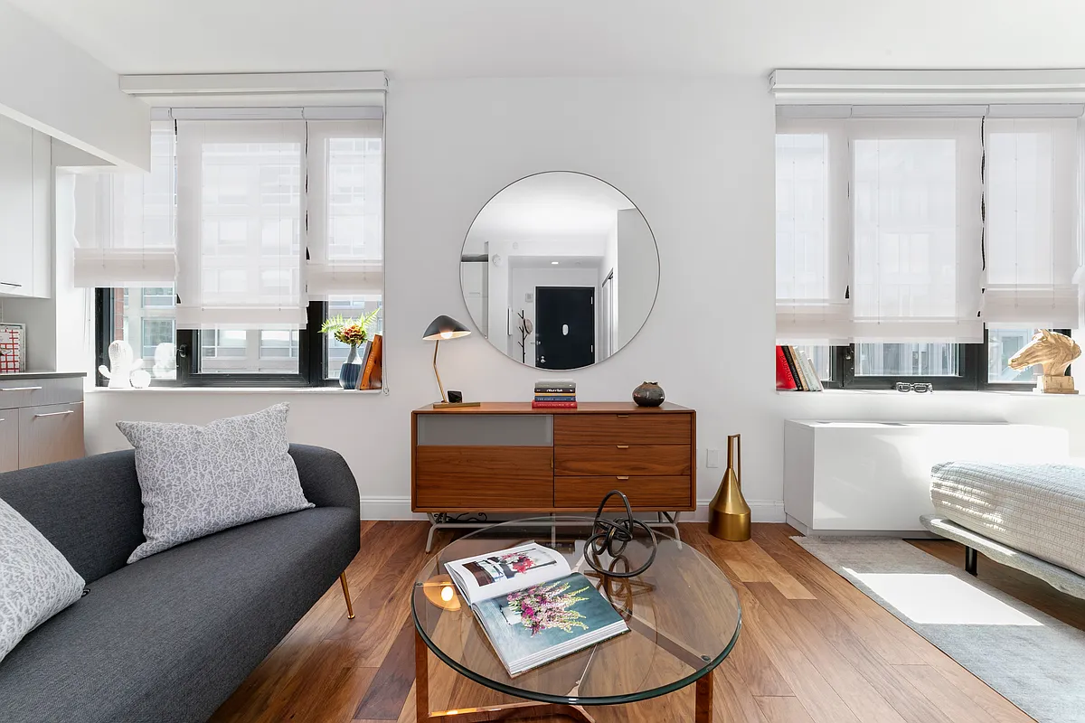 42-14 Crescent Street, Unit 9D Queens, NY 11101 - Photo 1 of 6 a living room with furniture and a mirror