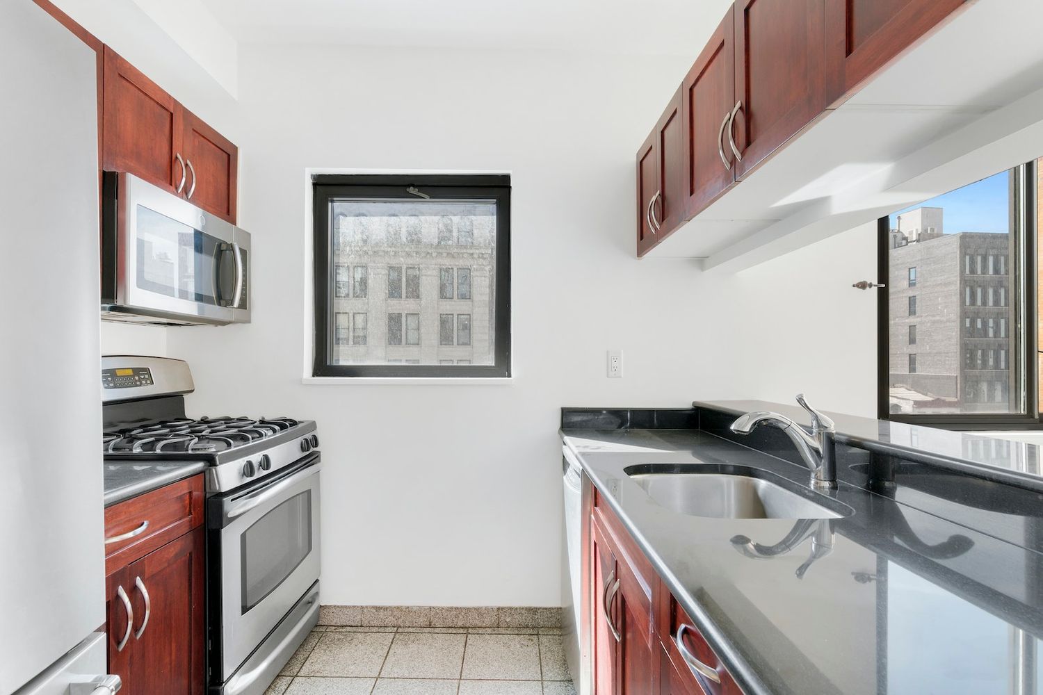 199 Bowery, Unit 5A Manhattan, NY 10002 - Photo 4 of 6 a kitchen with stainless steel appliances granite countertop a sink stove and cabinets