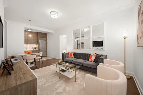 a living room with furniture and view of kitchen