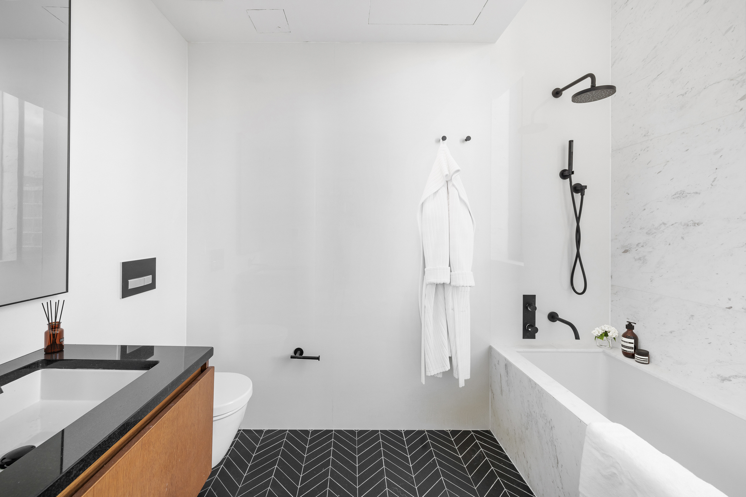 570 Broome Street, Unit 23A Manhattan, NY 10013 - Photo 11 of 13 a bathroom with a granite countertop sink and a bathtub