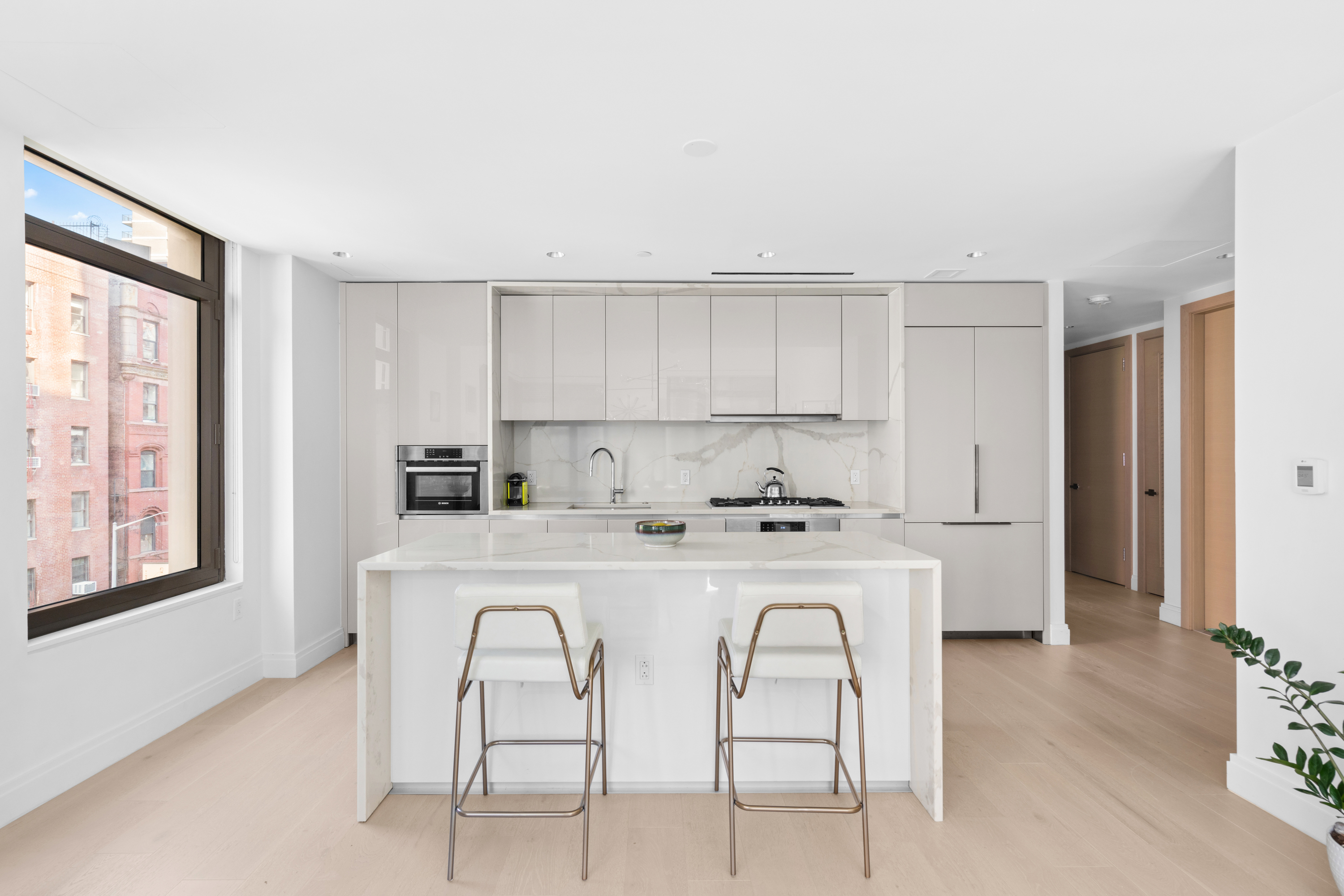 212 West 95th Street, Unit 4A Manhattan, NY 10025 - Photo 3 of 12 a kitchen with stainless steel appliances a table and chairs in it