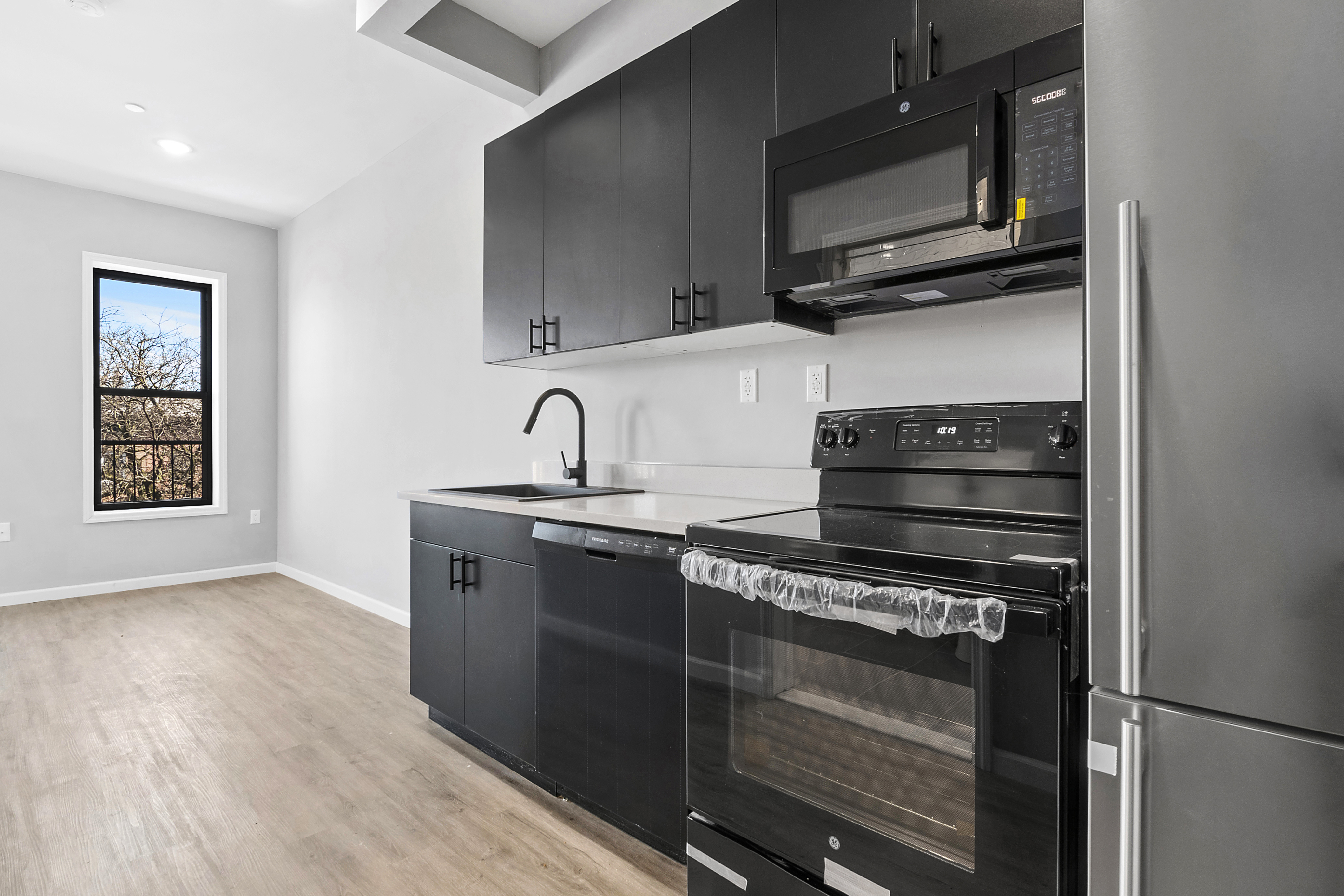 48 Cornelia Street, Unit 3C Brooklyn, NY 11221 - Photo 3 of 4 a kitchen with granite countertop a stove microwave and sink