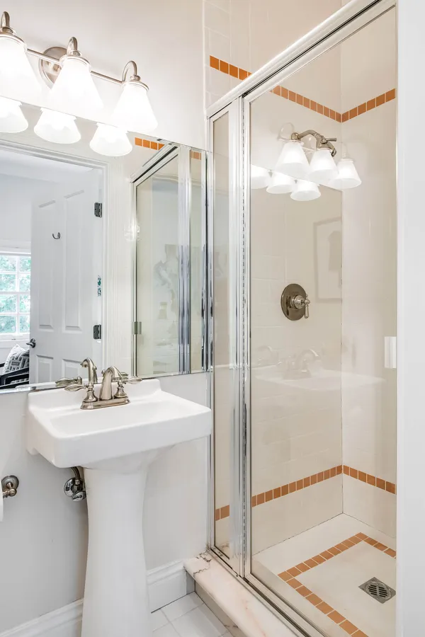 a bathroom with a shower sink and mirror