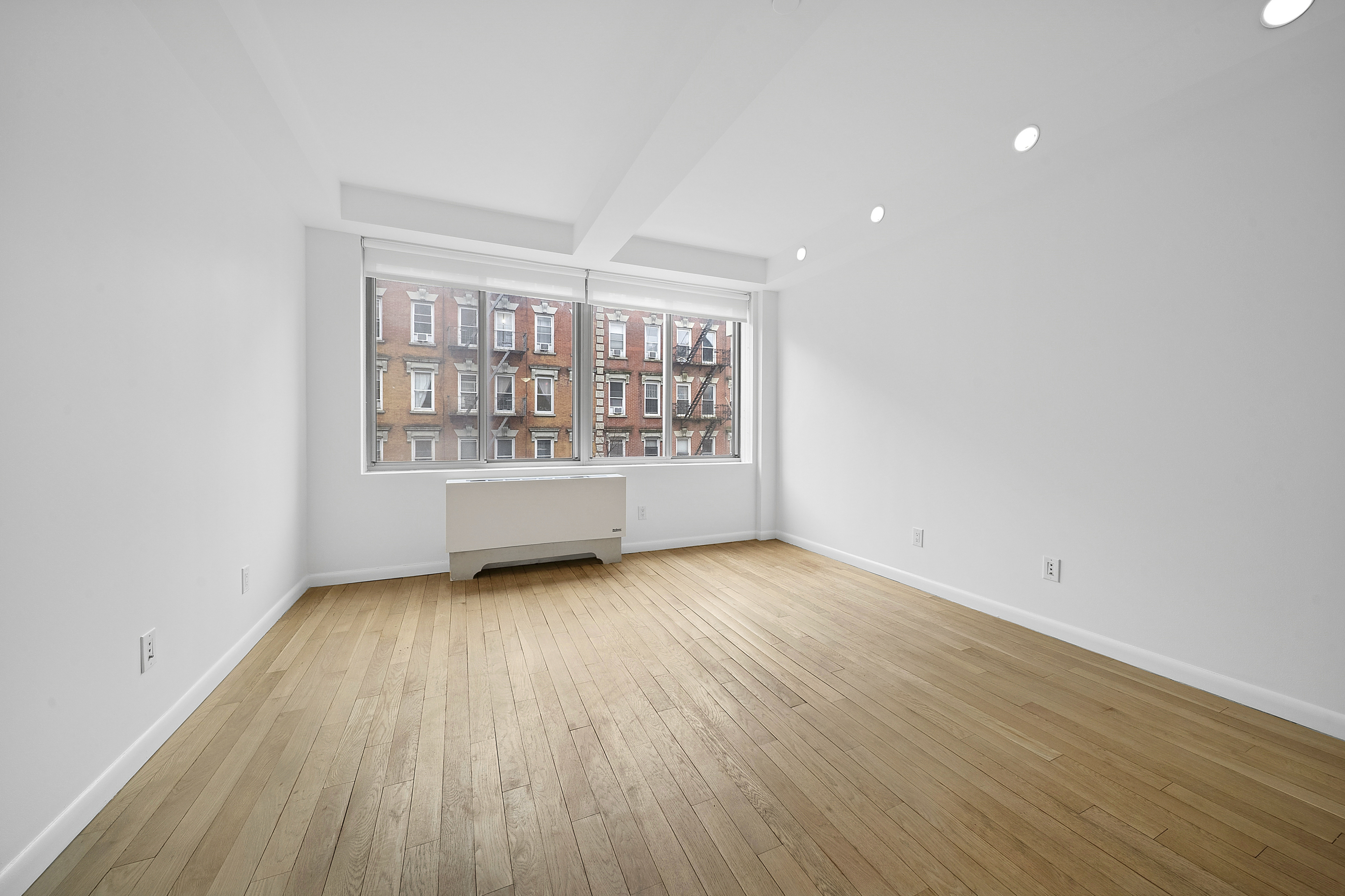 525 East 11th Street, Unit 4D Manhattan, NY 10009 - Photo 2 of 10 a view of an empty room with a window and wooden floor