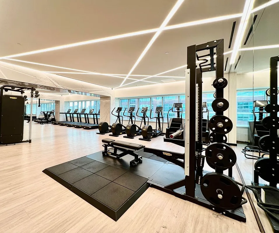 46-30 Center Boulevard, Unit 710 Queens, NY 11109 - Photo 13 of 25 a living room with lots of furniture and white walls