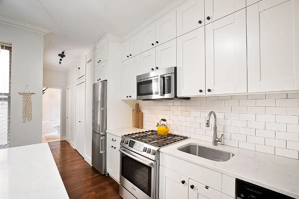 314 West 94th Street, Unit 5E Manhattan, NY 10025 - Photo 4 of 9 a kitchen with stainless steel appliances granite countertop grey cabinets a stove a sink and a refrigerator