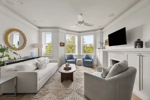 a living room with furniture a fireplace and a flat screen tv