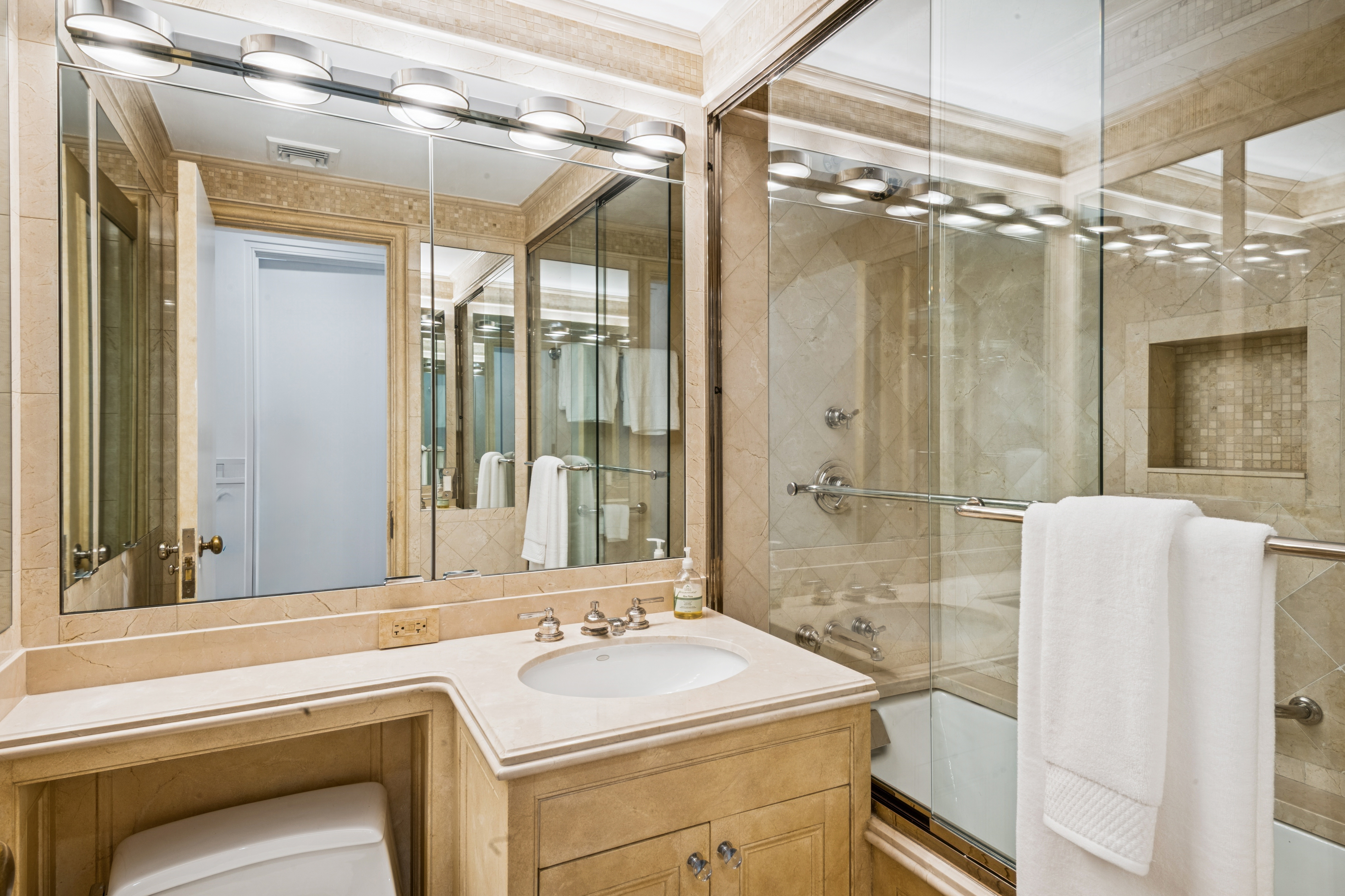 45 Sutton Place South, Unit 10F Manhattan, NY 10022 - Photo 11 of 15 a bathroom with a sink and mirror with bathtub