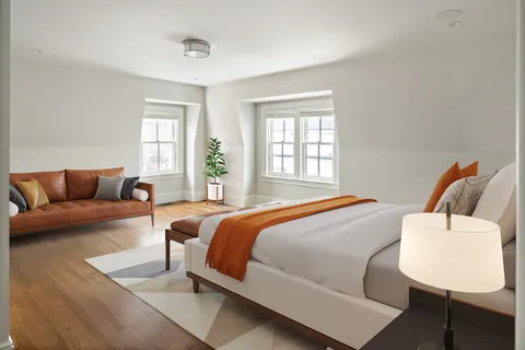 a bedroom with bed couch and window