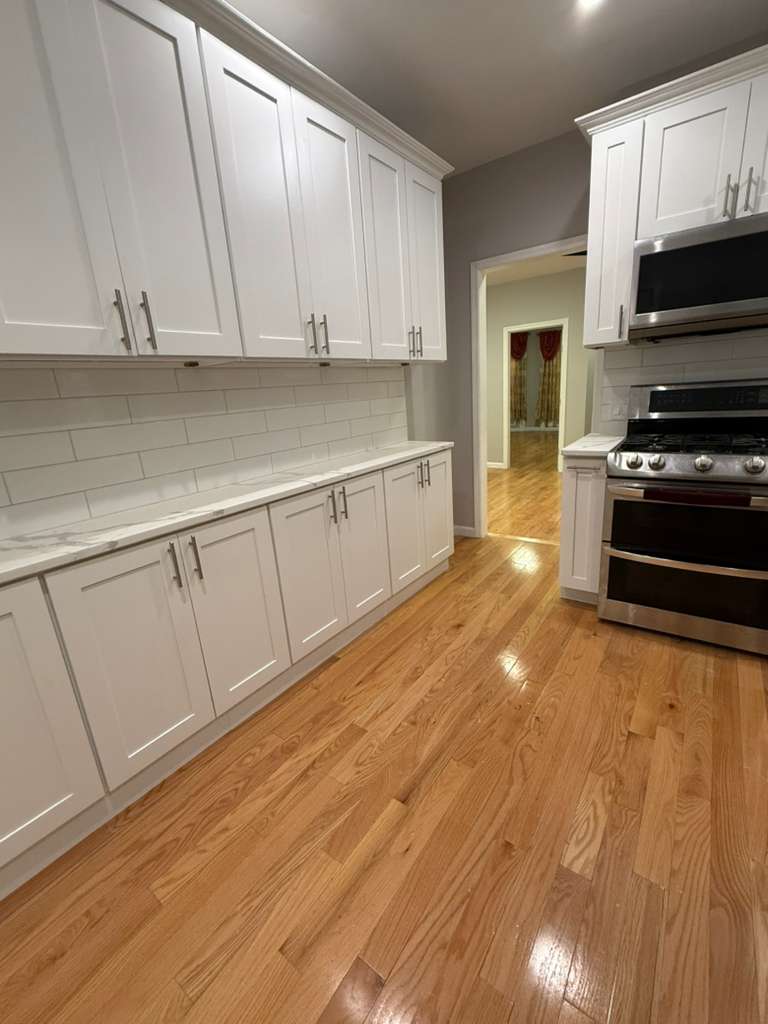 641 East 4th Street, Unit 1 Brooklyn, NY 11218 - Photo 11 of 15 a kitchen with granite countertop a stove a sink and a microwave