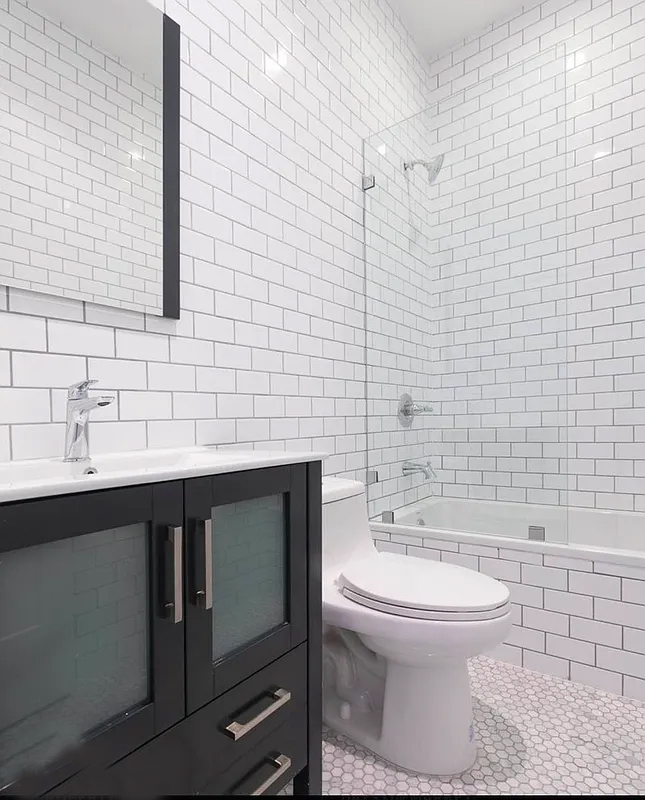 1128 Halsey Street, Unit 1 Brooklyn, NY 11207 - Photo 3 of 6 a bathroom with a sink a toilet and shower