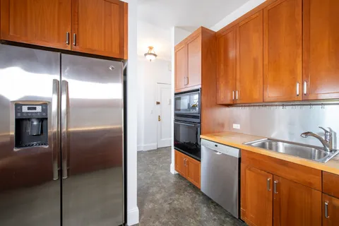 a kitchen with stainless steel appliances granite countertop a refrigerator a sink and dishwasher with cabinets