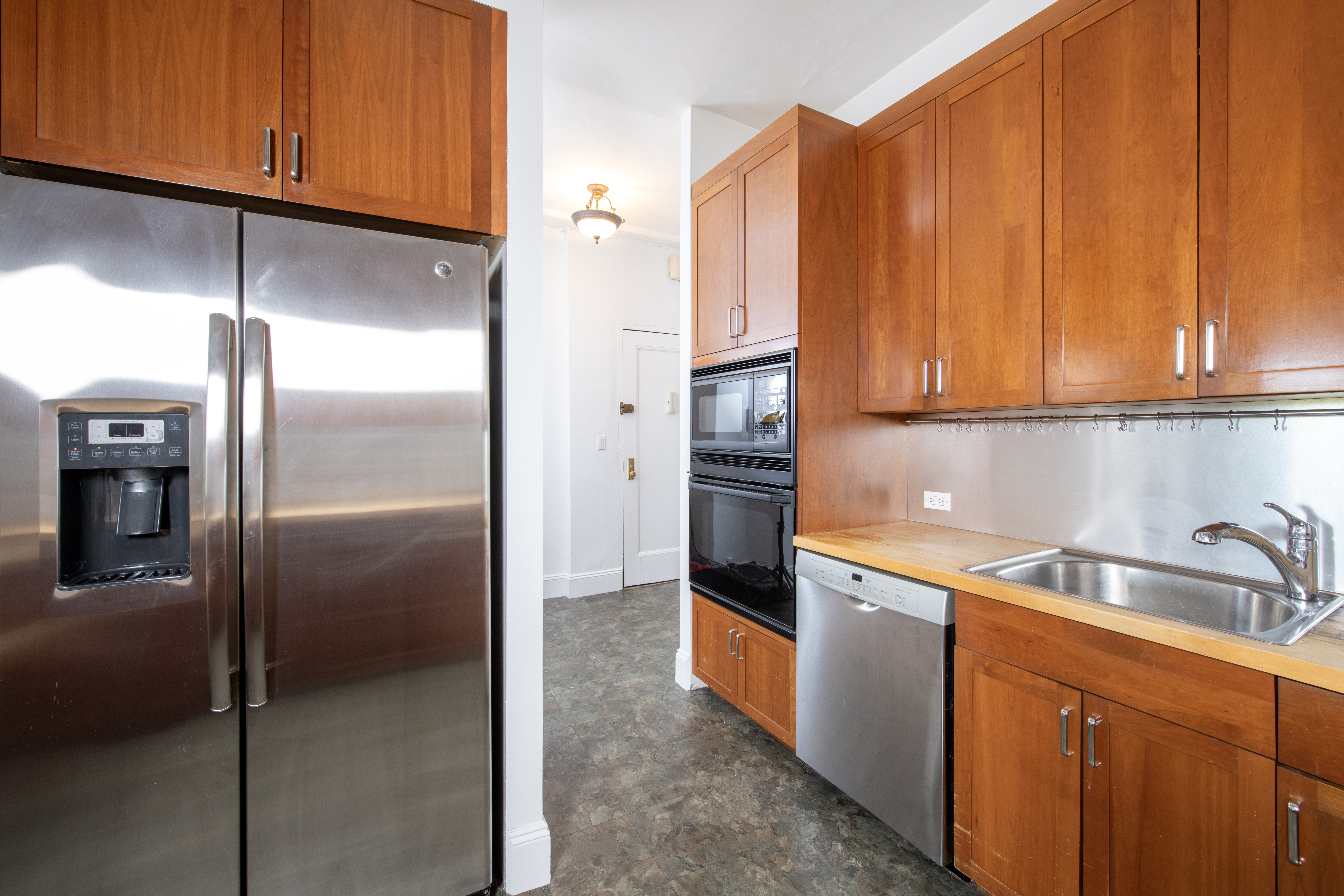 299 Riverside Drive, Unit 4D Manhattan, NY 10025 - Photo 4 of 15 a kitchen with stainless steel appliances granite countertop a refrigerator a sink and dishwasher with cabinets