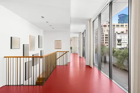 a view of a hallway with wooden floor and windows