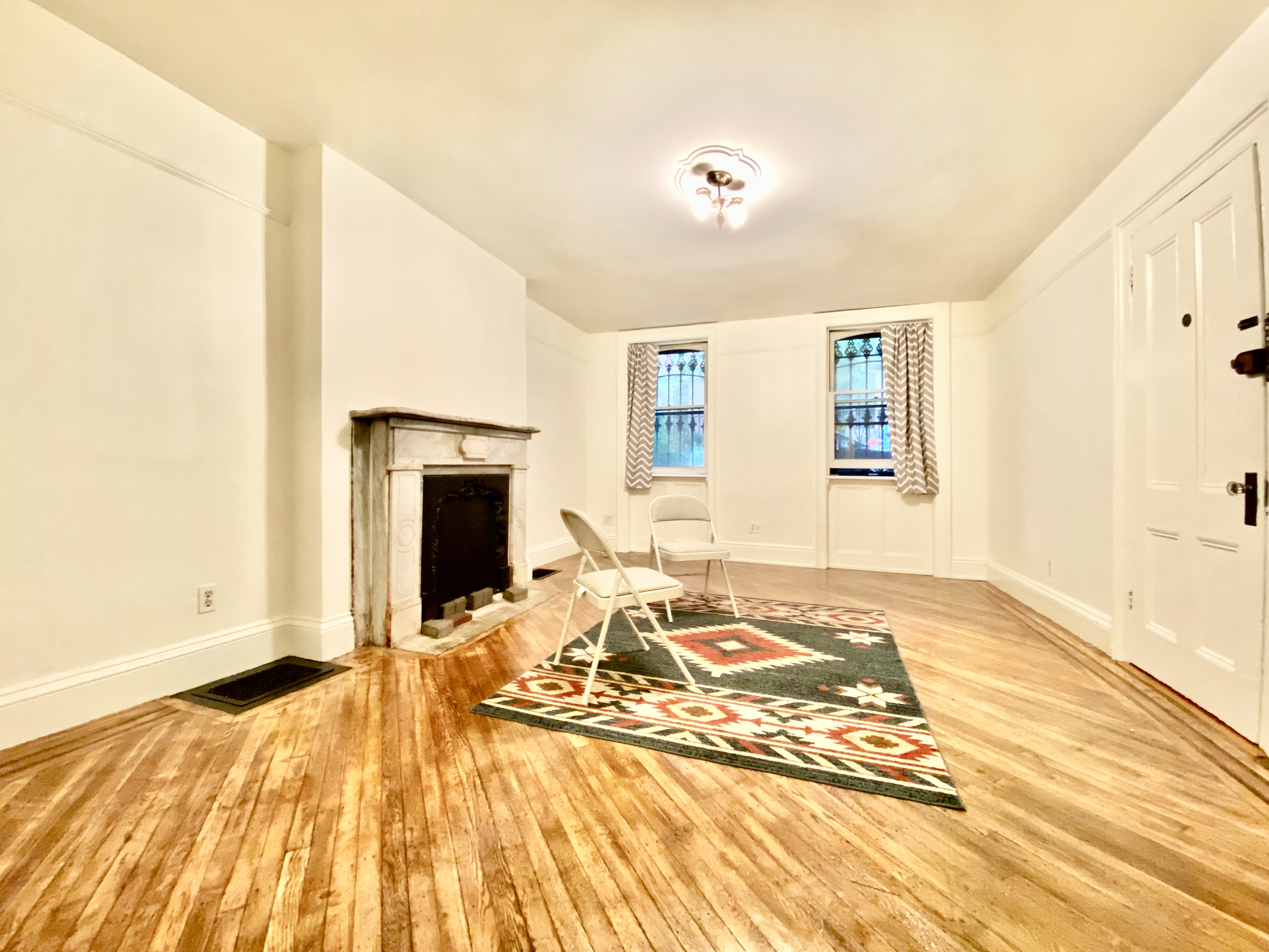 a view of a bedroom with wooden floor and a window