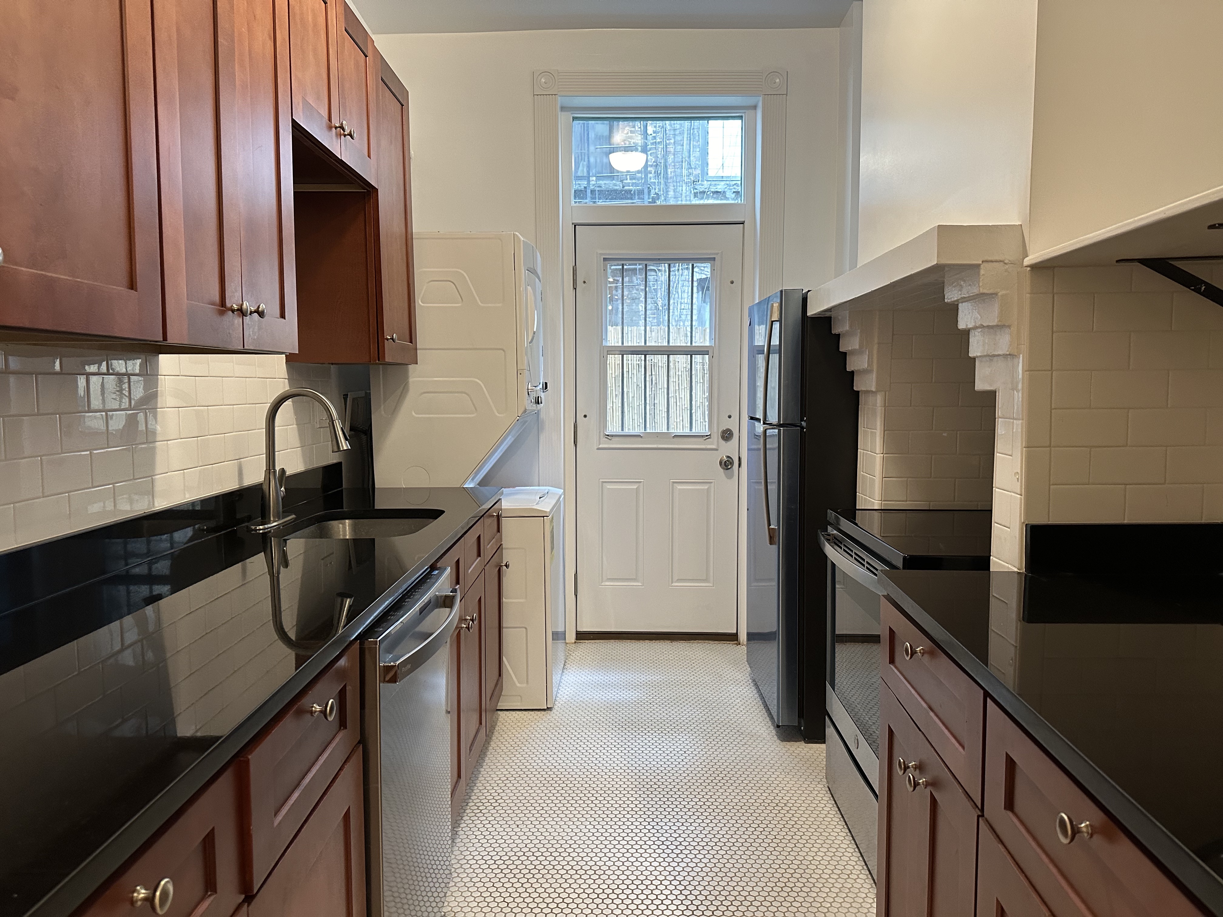 459 West 35th Street, Unit 1E Manhattan, NY 10001 - Photo 12 of 18 a kitchen with granite countertop a refrigerator stove and sink