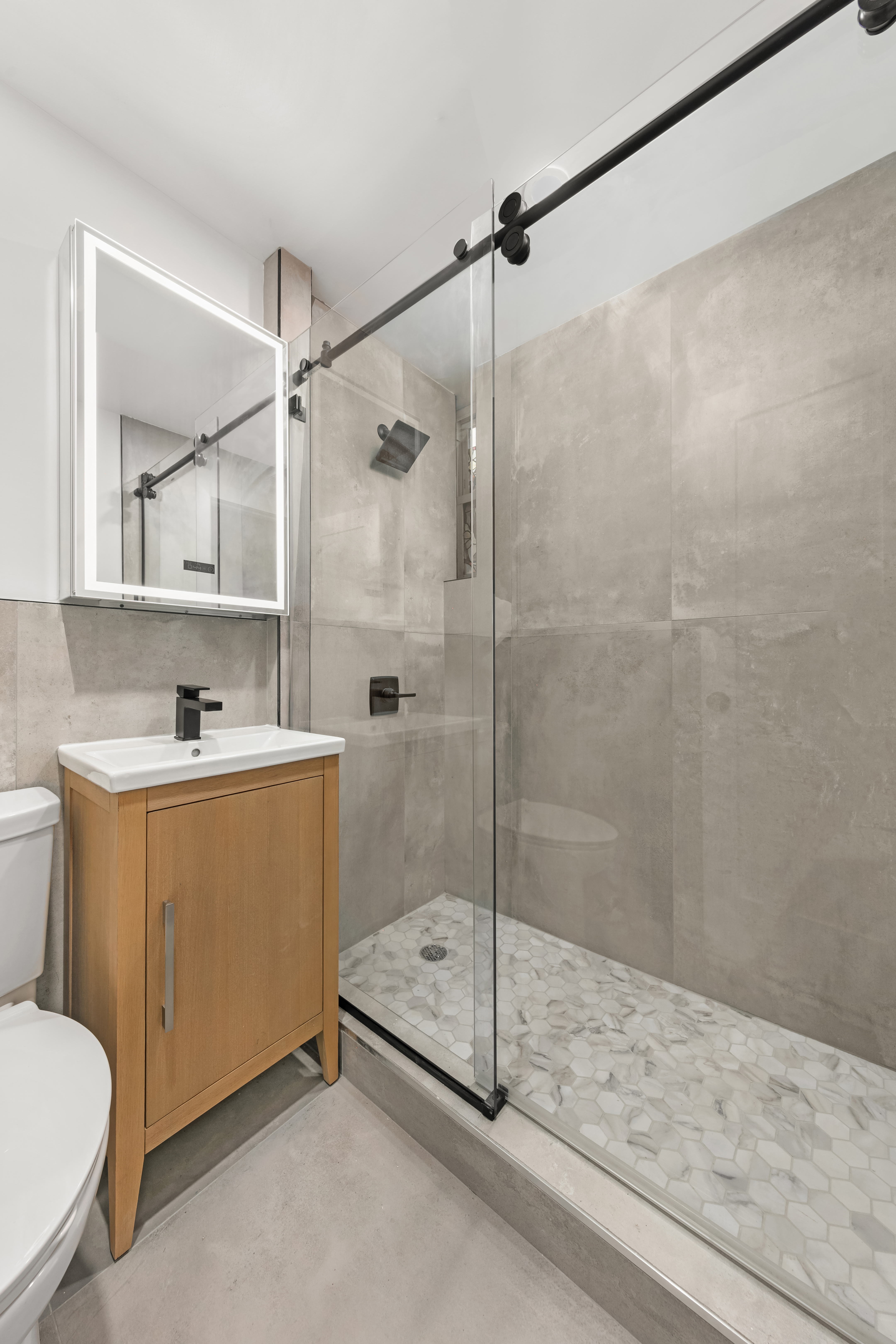 227 East 21st Street, Unit 4F Manhattan, NY 10010 - Photo 5 of 6 a bathroom with a sink mirror vanity and toilet