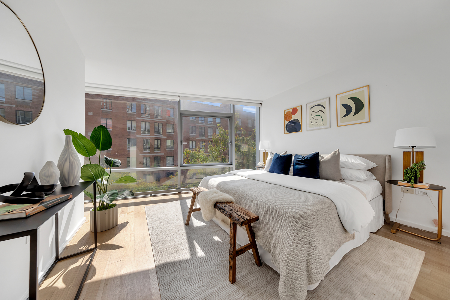 425 West 53rd Street, Unit 419 Manhattan, NY 10019 - Photo 7 of 18 a bedroom with a bed table flowerpot and a window