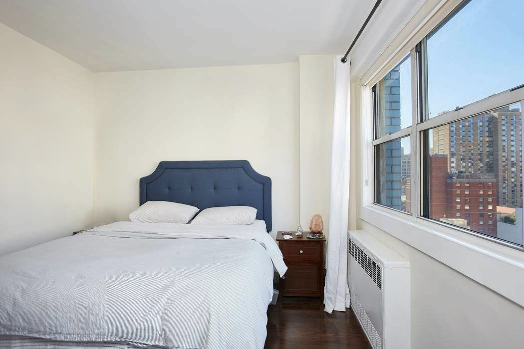 111 3rd Avenue, Unit PHK Manhattan, NY 10003 - Photo 3 of 11 a bedroom with a bed and a large window with outer view