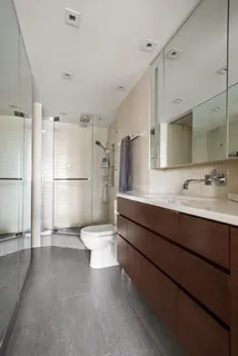 a bathroom with a toilet sink a mirror and shower