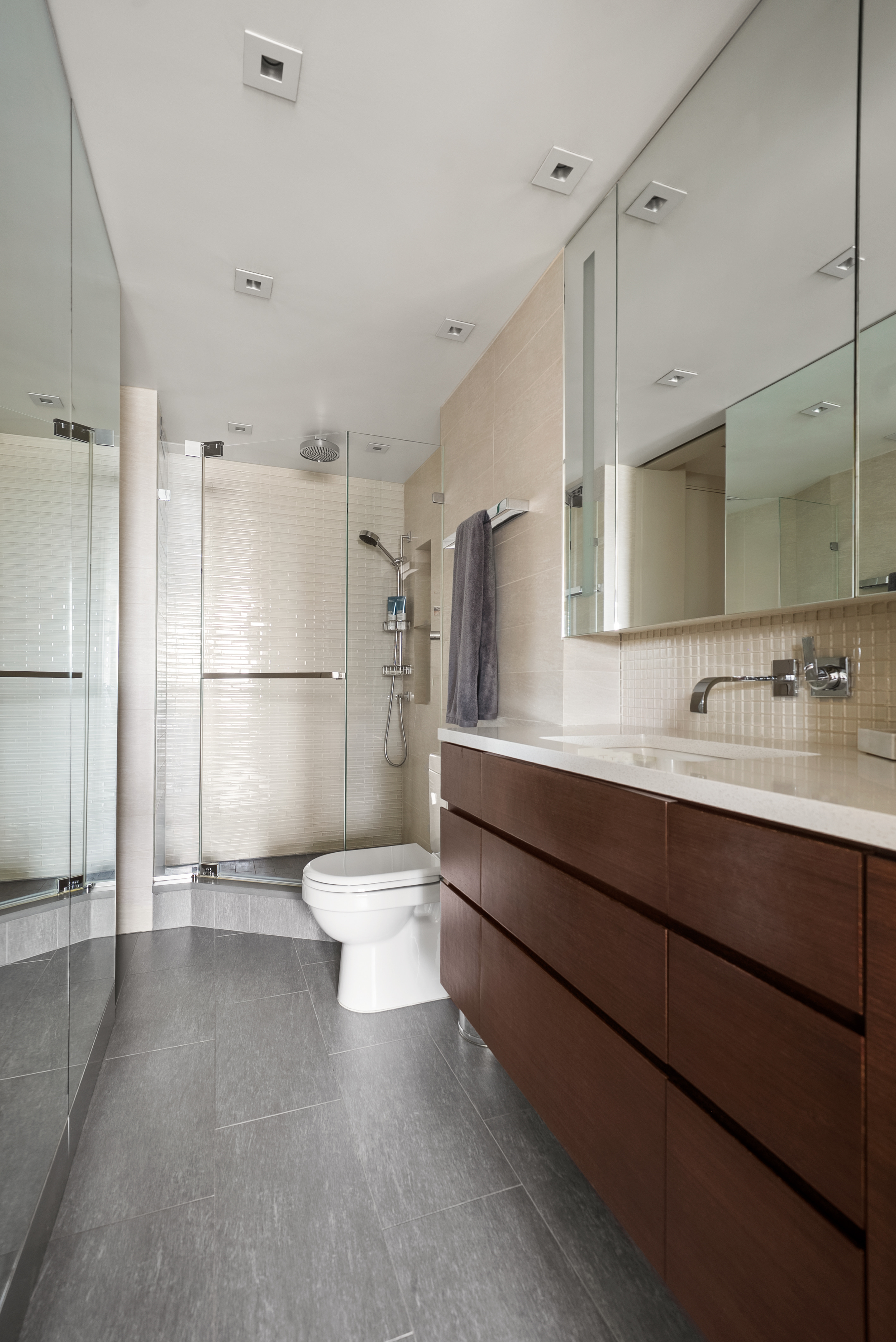 165 West 66th Street, Unit 18D Manhattan, NY 10023 - Photo 6 of 8 a bathroom with a toilet sink a mirror and shower