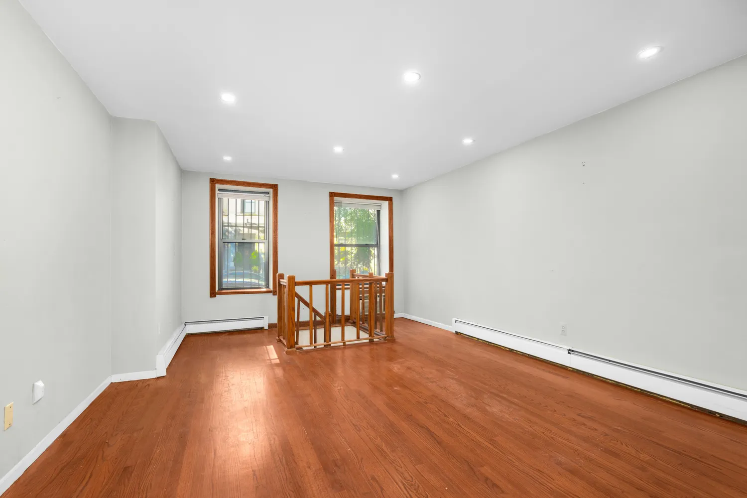 an empty room with wooden floor and glass door