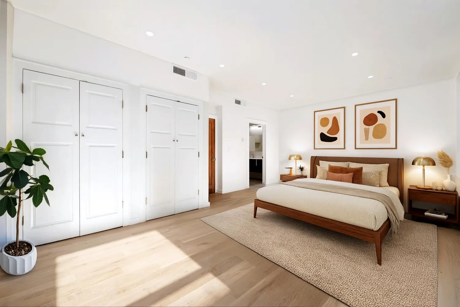 a spacious bedroom with a bed and a plant