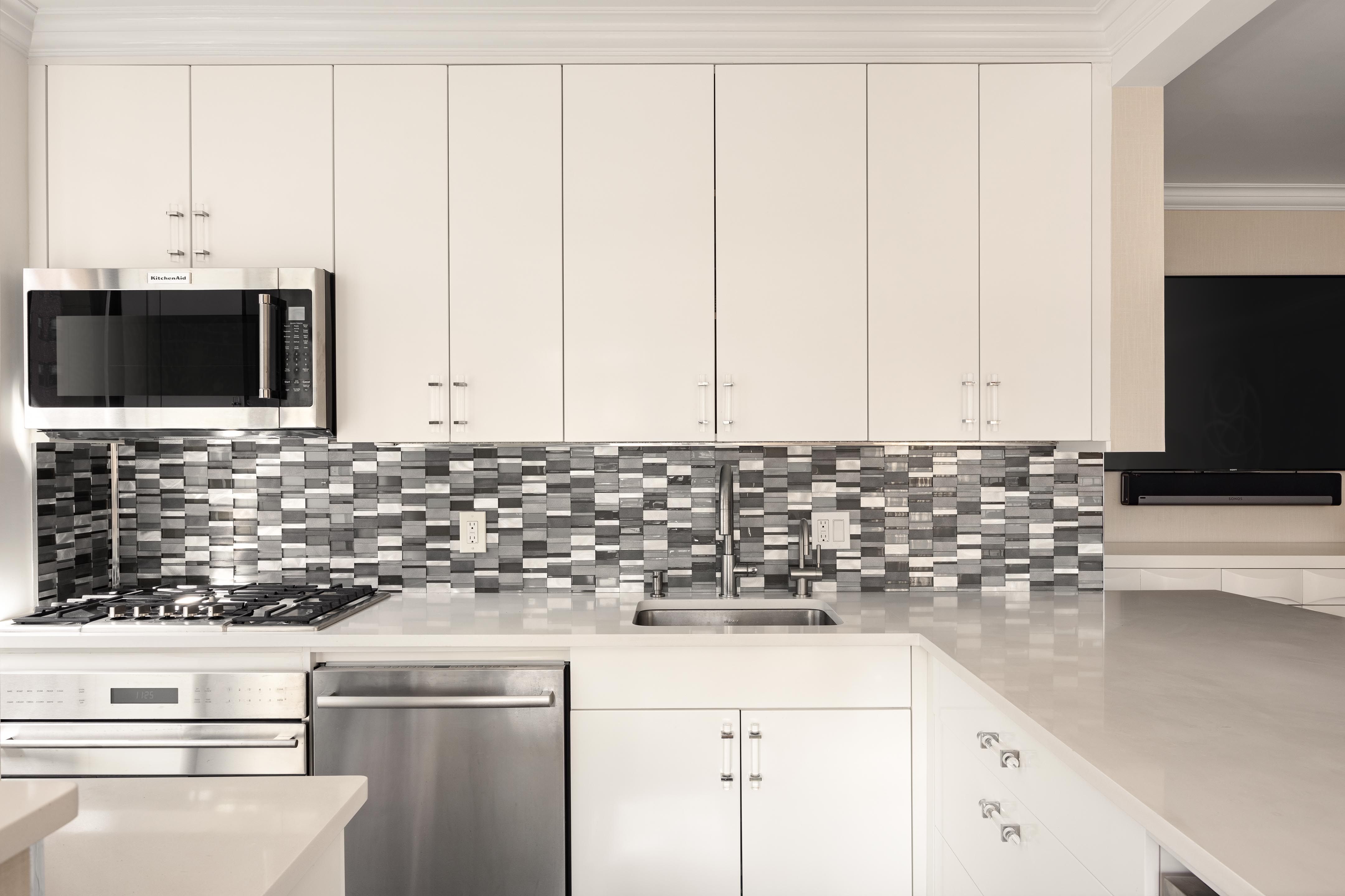 171 East 84th Street, Unit 7B Manhattan, NY 10028 - Photo 7 of 19 a kitchen with stainless steel appliances white cabinets and a sink