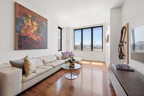a living room with furniture two window and wooden floor