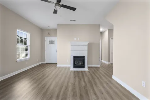 wooden floor fireplace and windows in an empty room