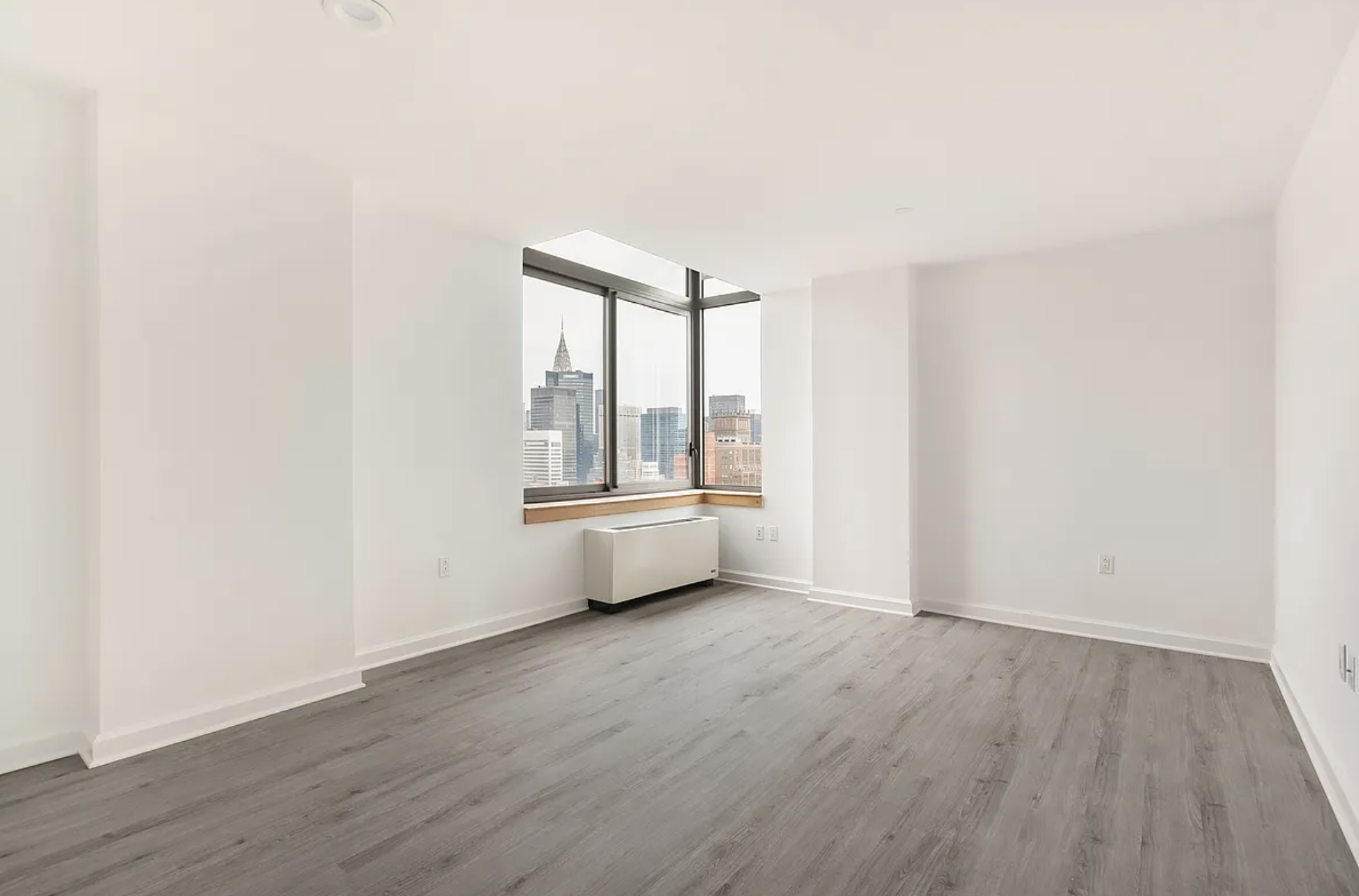 35 West 33rd Street, Unit 32C Manhattan, NY 10001 - Photo 4 of 21 an empty room with wooden floor and windows