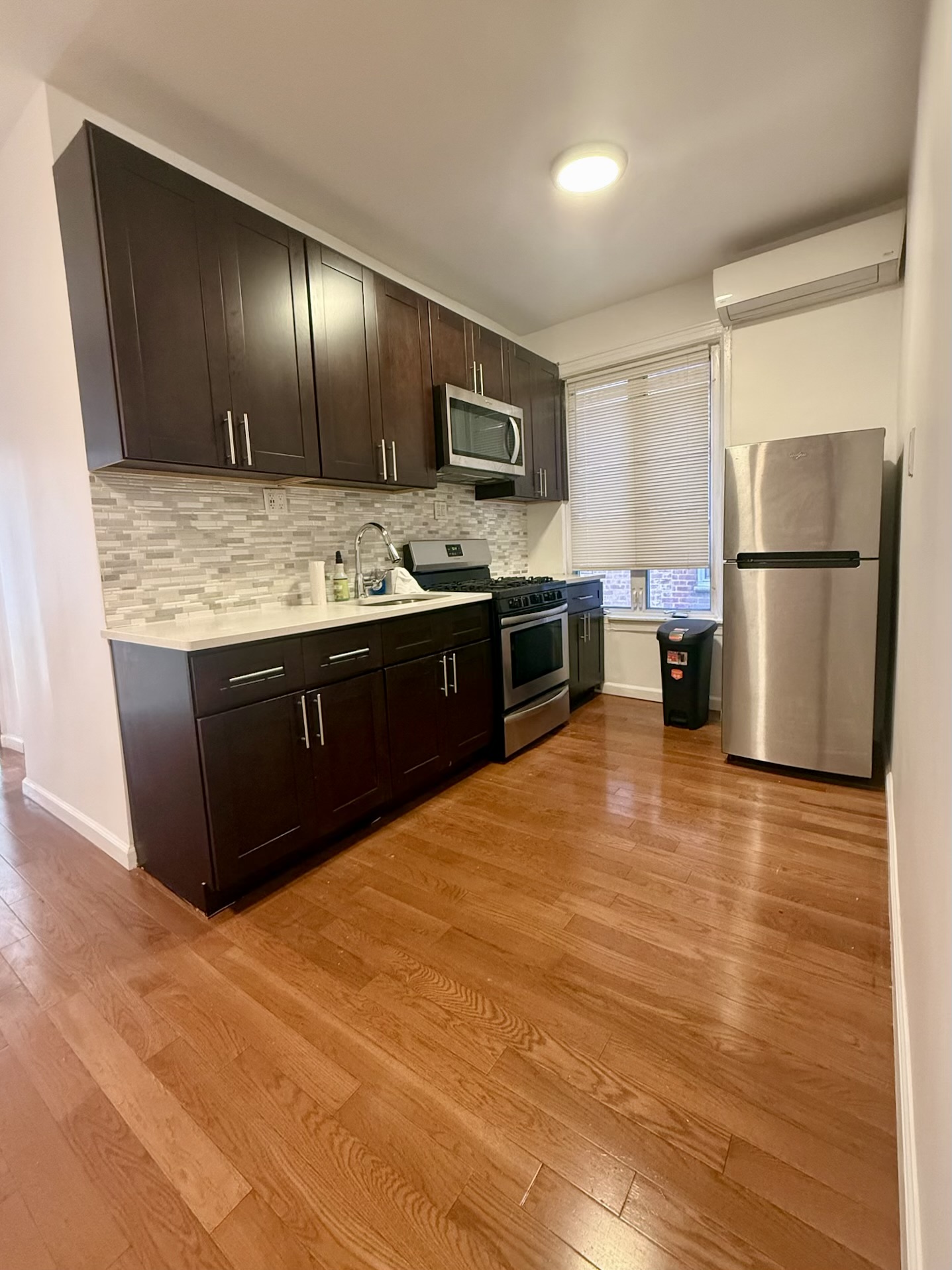 18-48 21st Drive, Unit 1R Queens, NY 11105 - Photo 8 of 11 a kitchen with stainless steel appliances granite countertop a stove and a refrigerator