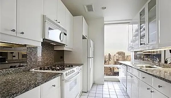 845 United Nations Plaza, Unit 56E Manhattan, NY 10017 - Photo 10 of 28 a kitchen with stainless steel appliances granite countertop a stove a sink and a refrigerator