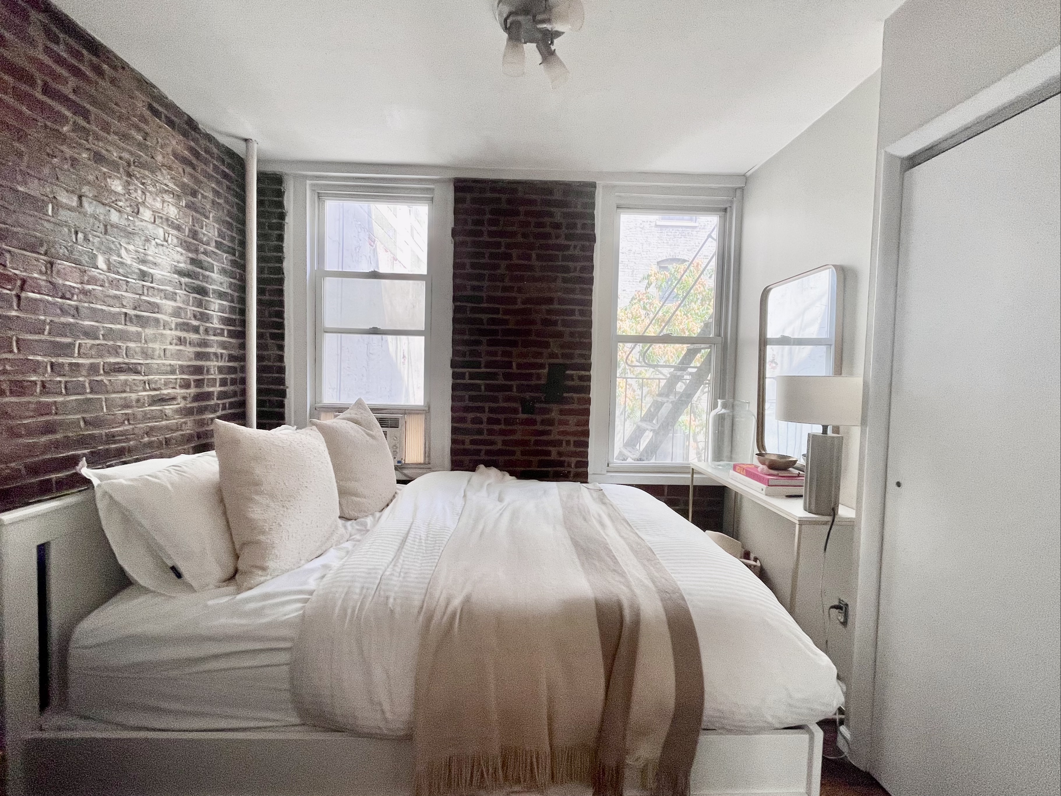 57 Spring Street, Unit 6 Manhattan, NY 10012 - Photo 3 of 10 a bedroom with a bed and a large window