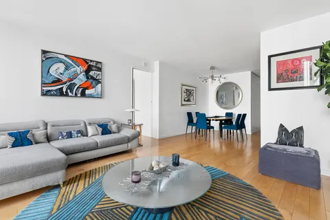 a living room with furniture and a wooden floor