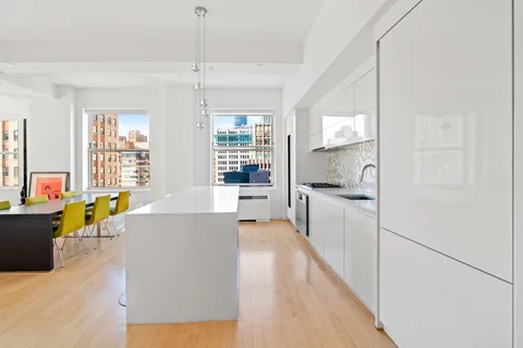 a large living room with stainless steel appliances kitchen island granite countertop a refrigerator a stove a sink dishwasher and a dining table with wooden floor