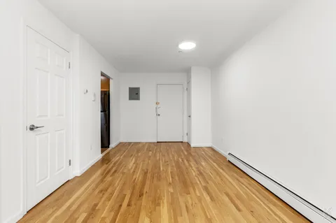 a view of a room with wooden floor and a hallway