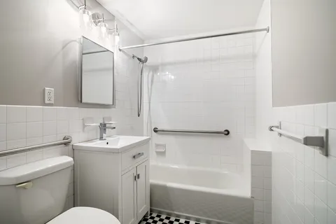 a bathroom with a sink mirror toilet and bathtub