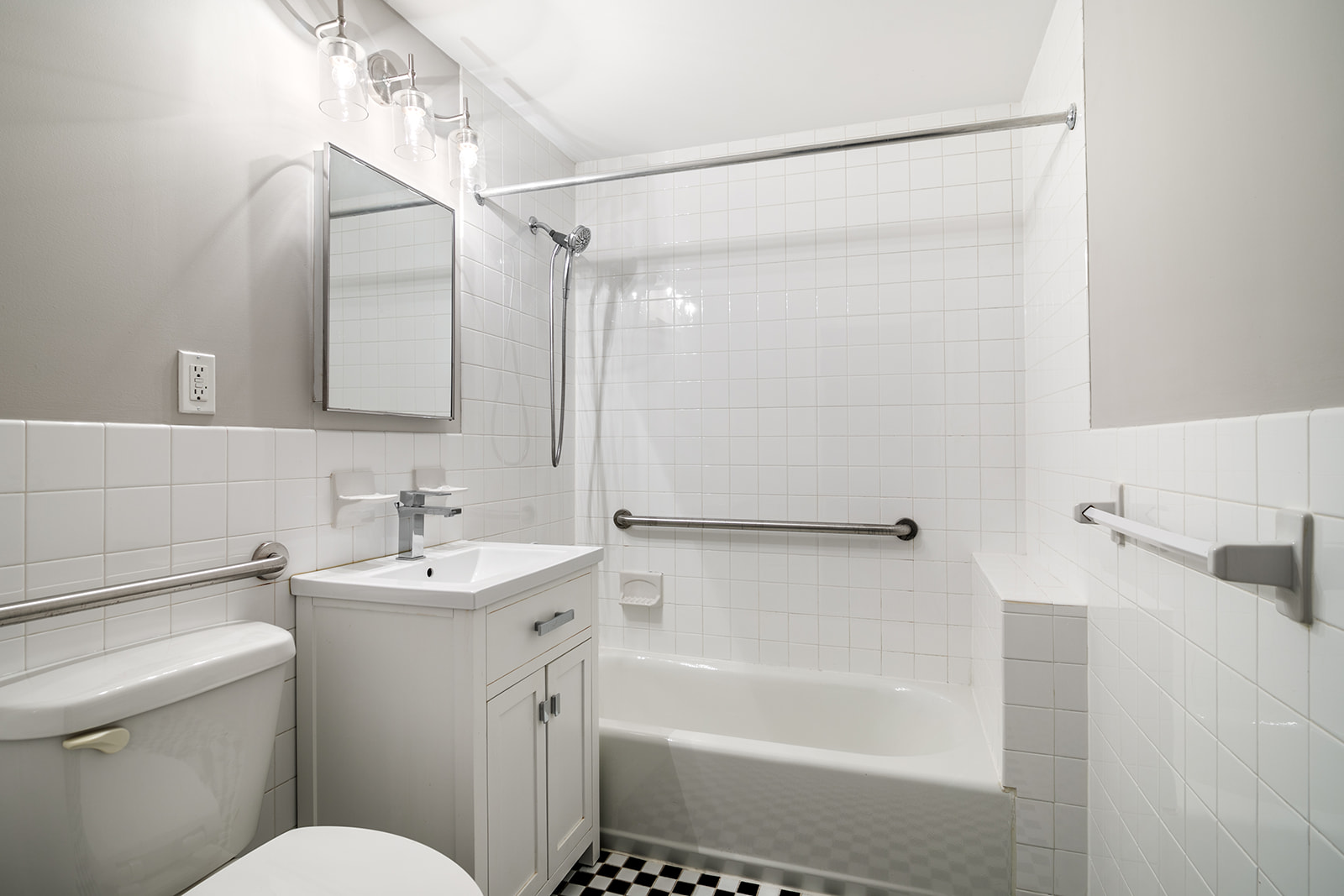 265 West 136th Street Manhattan, NY 10030 - Photo 12 of 14 a bathroom with a sink mirror toilet and bathtub