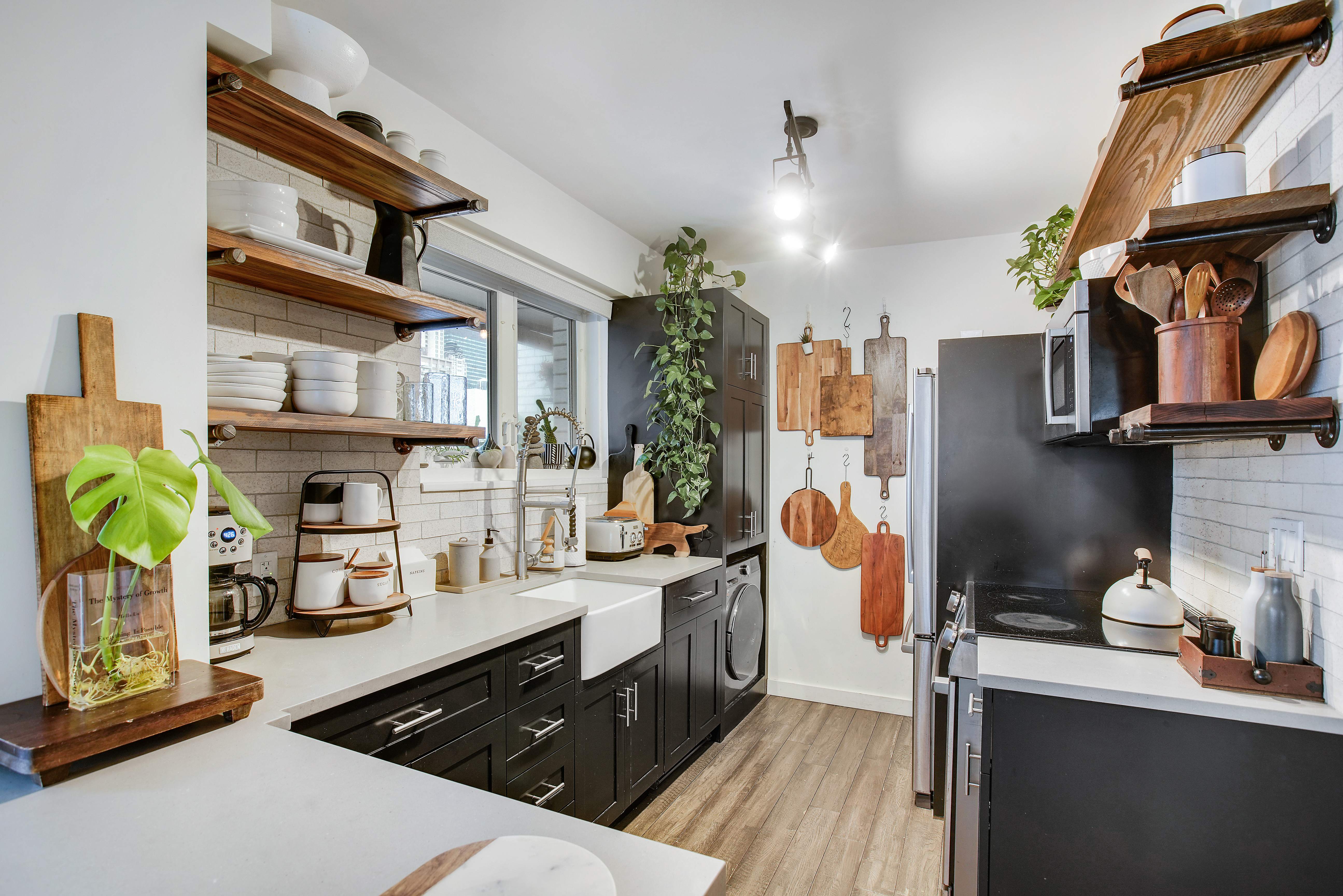175 East 62nd Street, Unit 18B Manhattan, NY 10065 - Photo 7 of 18 a kitchen with a sink dishwasher a stove and a microwave oven with white cabinets