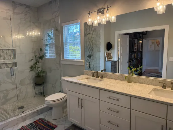 a bathroom with a sink and mirror with toilet