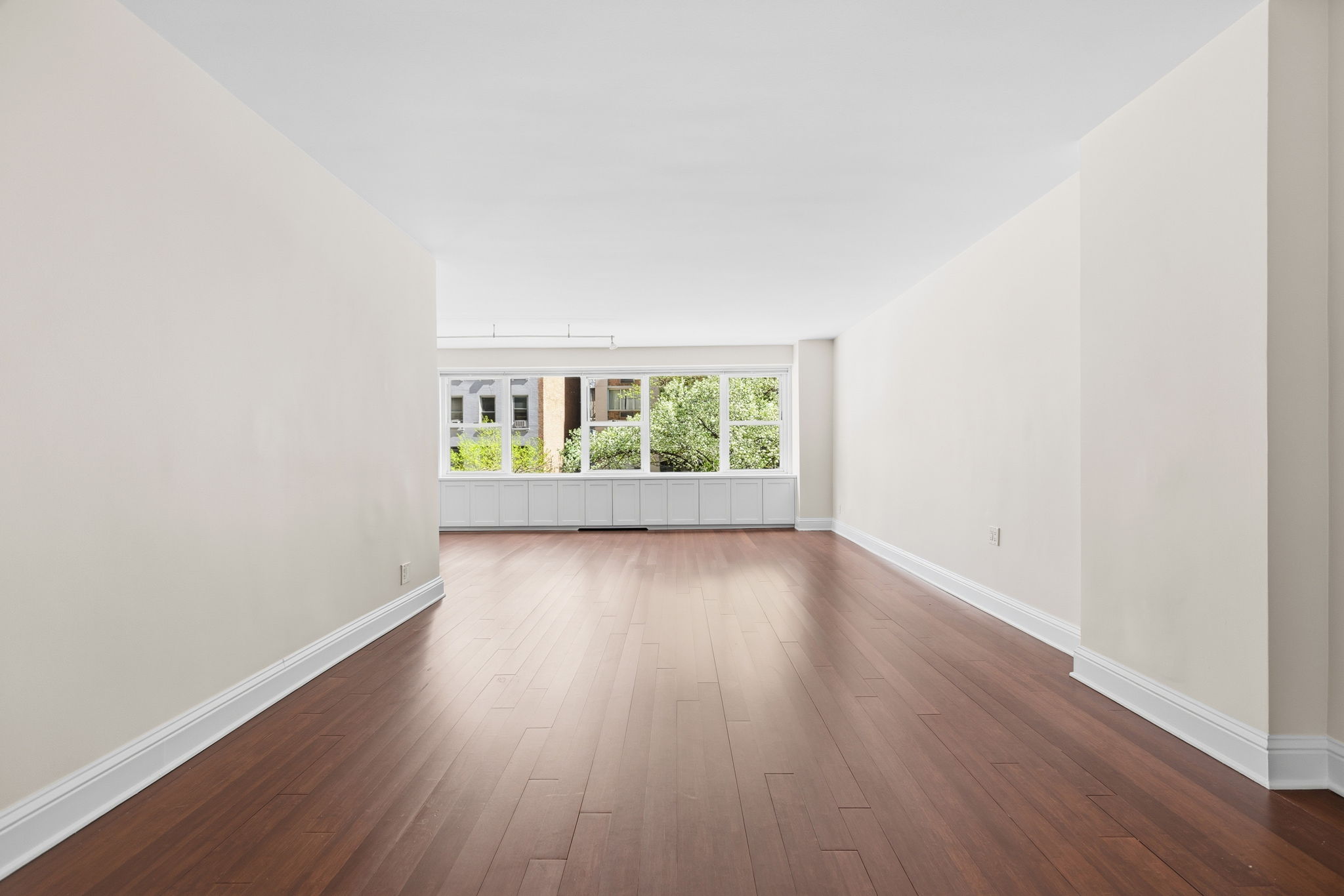 360 East 72nd Street, Unit A306 Manhattan, NY 10021 - Photo 16 of 17 an empty room with wooden floor and windows