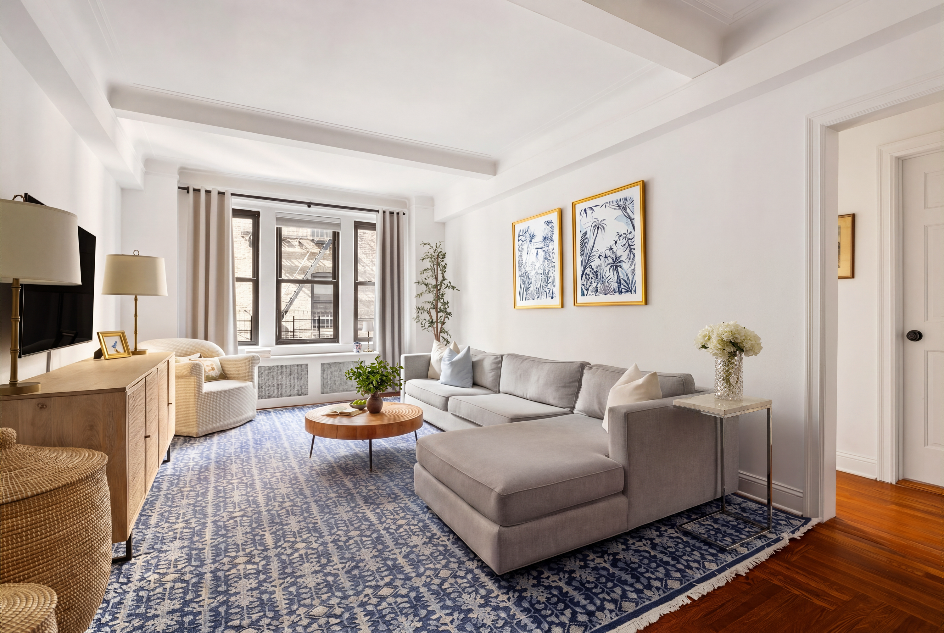 60 East 96th Street, Unit 6C Manhattan, NY 10128 - Photo 1 of 9 a living room with furniture and a flat screen tv