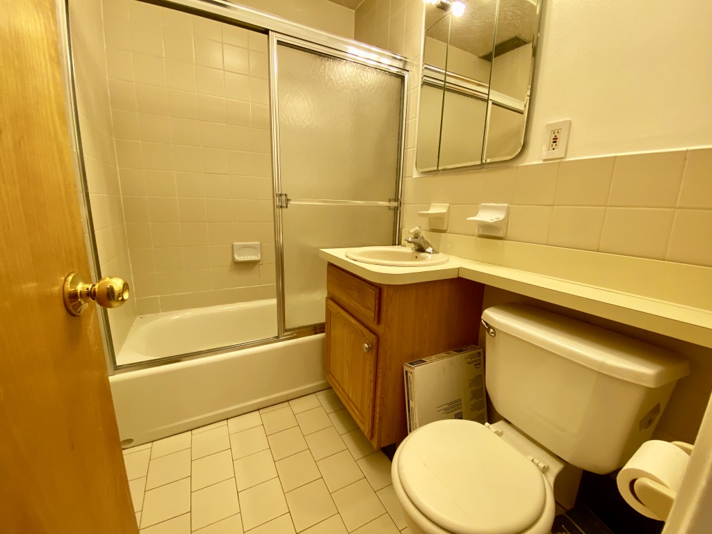 619 9th Avenue, Unit 3E Manhattan, NY 10036 - Photo 6 of 22 a bathroom with a sink mirror vanity and toilet