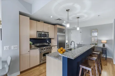 a kitchen with a center island and stainless steel appliances with cabinets