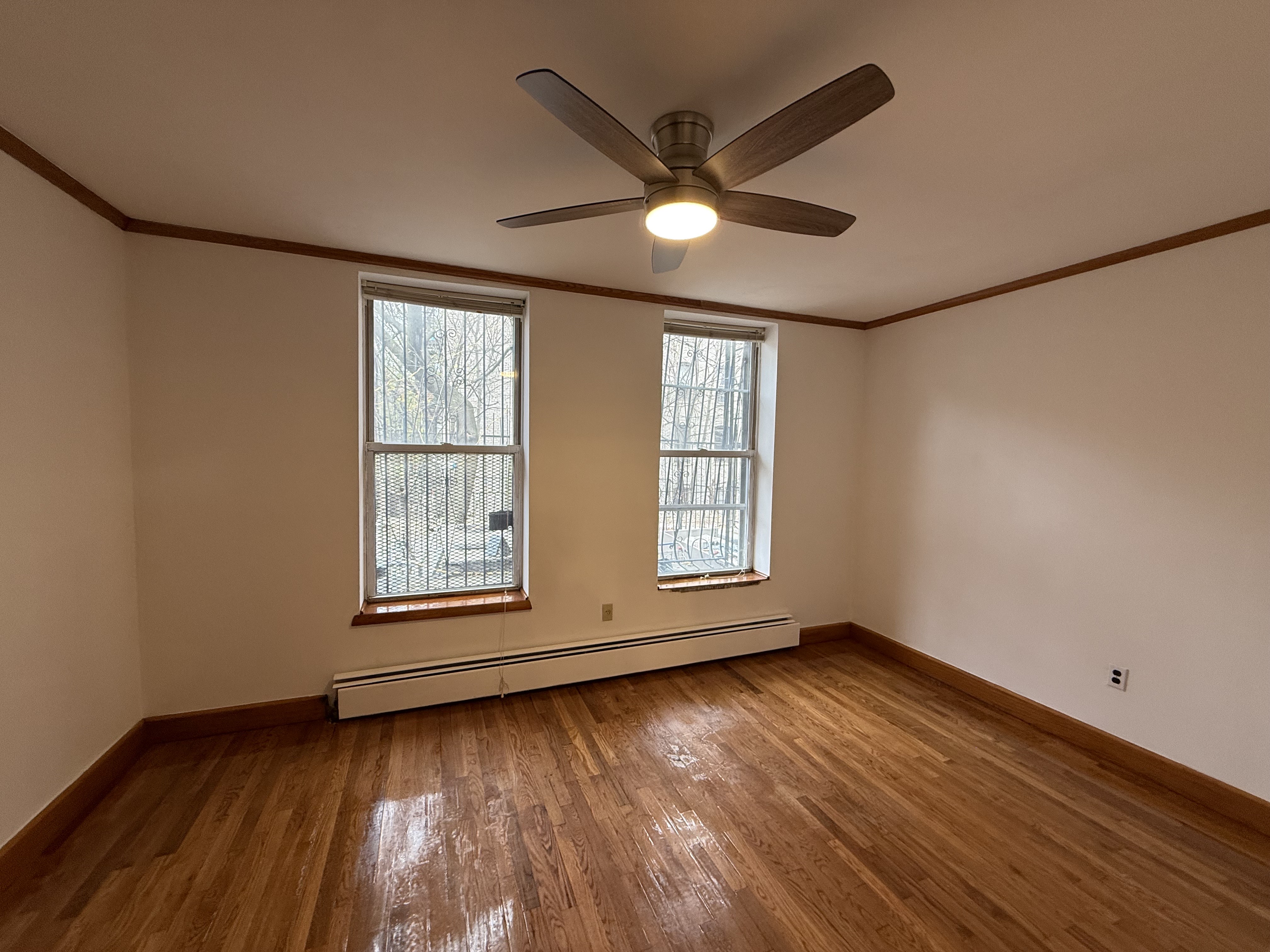 423 Lincoln Place, Unit 2 Brooklyn, NY 11238 - Photo 2 of 6 a view of an empty room with wooden floor and a window