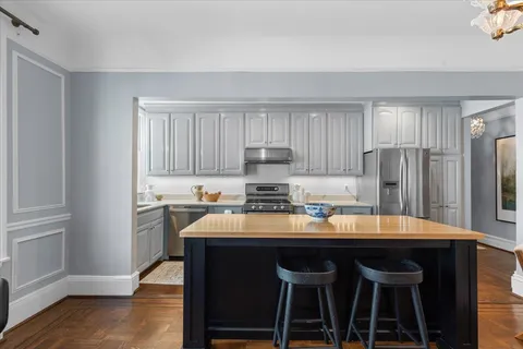 a kitchen with granite countertop a stove and a white cabinets